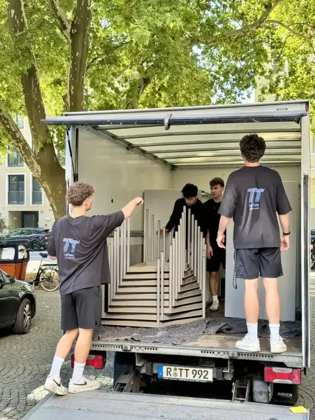 Mitarbeiter von TopTrans Regensburg beladen Umzugsgut in einen LKW