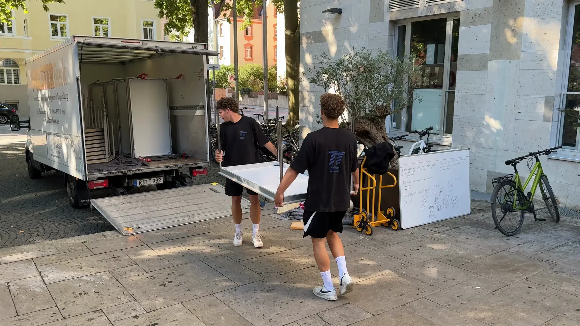 TopTrans Team trägt Möbel zum Umzugstransporter